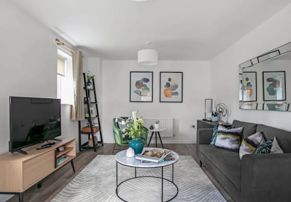 a living room with a gray couch and a round coffee table