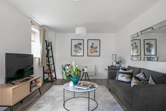 a living room with a gray couch and a round coffee table