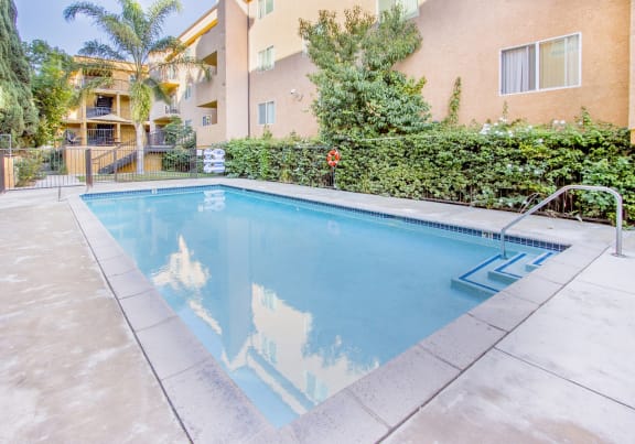 a swimming pool with an apartment in the background at Dronfield Astoria Apartments, Sylmar, California, 91342