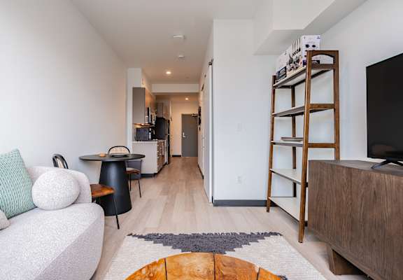 A living room with a white couch and a wooden bookshelf.