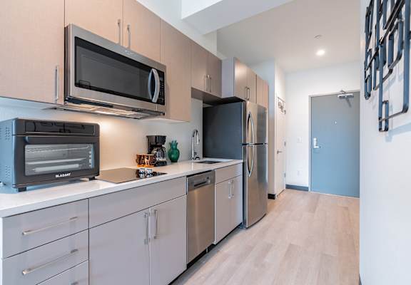 A kitchen with a black microwave above a black toaster oven.
