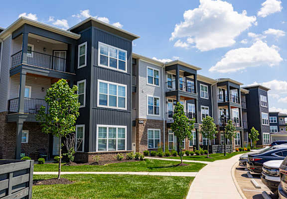 Apartment complex with a mix of grey and white buildings.