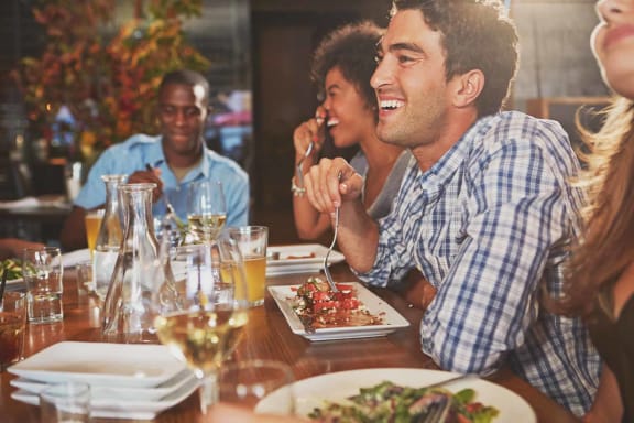 people sitting at a table eating food at a restaurant