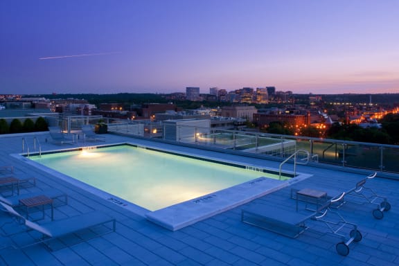 a pool on the roof of a building with a city in the background