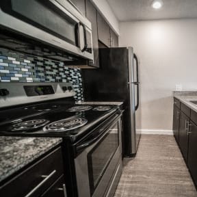 a kitchen with black and white appliances and granite counter tops