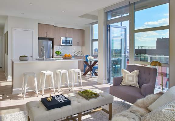 A modern living room with a bar area and a view of the city.