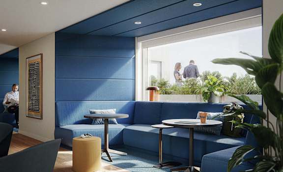 A blue couch with a white table in front of it.
