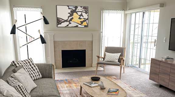 a living room with a gray couch and a yellow and blue rug