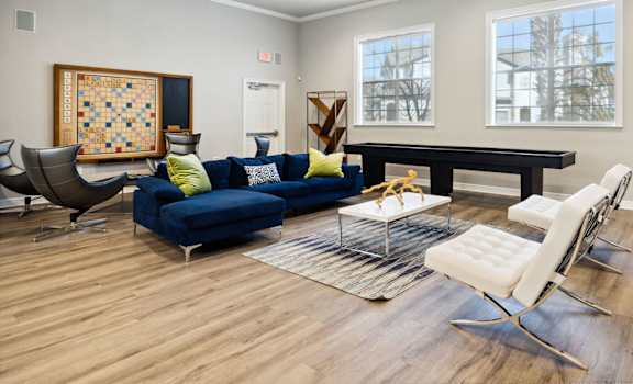 A living room with a blue couch and a wooden floor.
