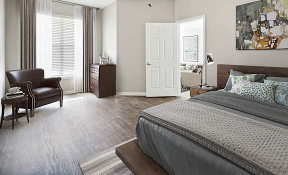 A bedroom with a large bed and a painting on the wall.