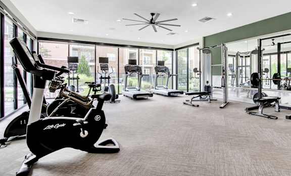 a large fitness room with treadmills and other exercise equipment