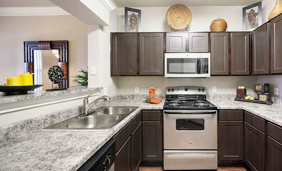 A kitchen with brown cabinets and a white refrigerator.
