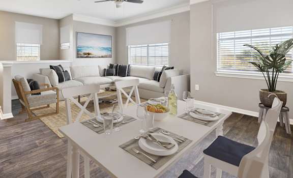 A dining room with a white table set for a meal.