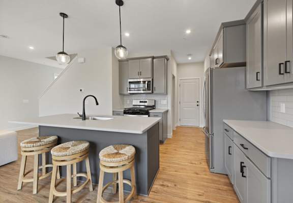 a kitchen with a center island and three stools