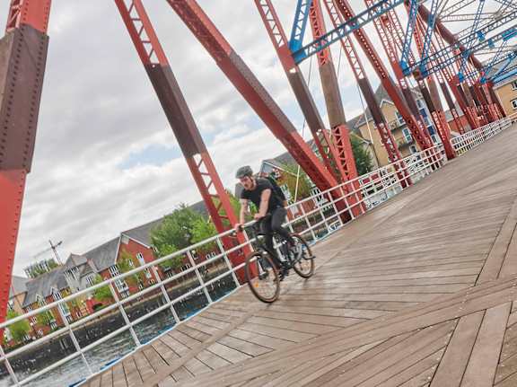 A man riding a bicycle on a wooden walkway.