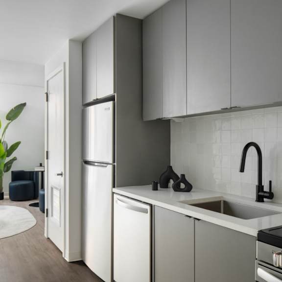 A modern kitchen with white cabinets and a black faucet.
