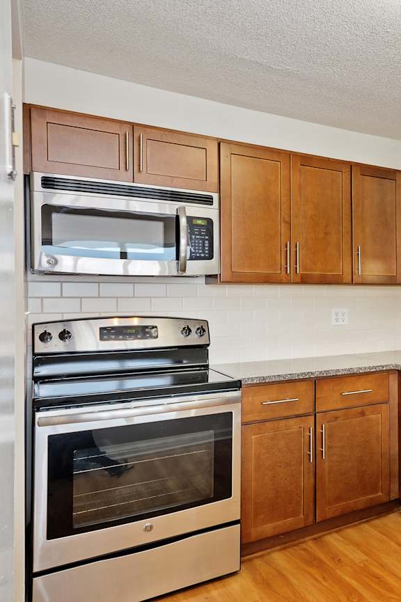 A kitchen with wooden cabinets and stainless steel appliances.
