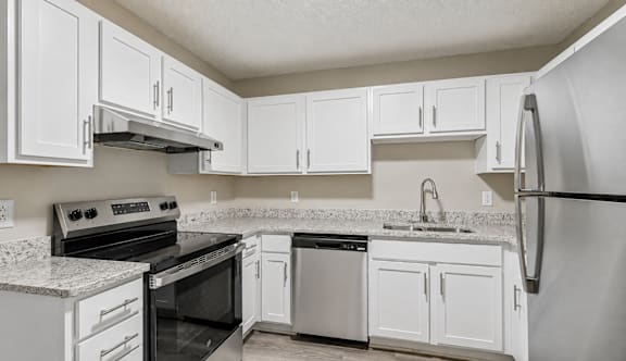 A kitchen with white cabinets and appliances.
