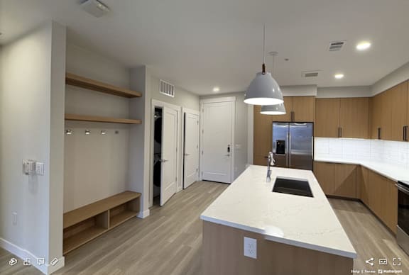 A modern kitchen with a central island and a large window.