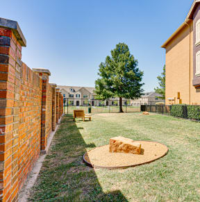 a backyard with a grassy area and a brick building