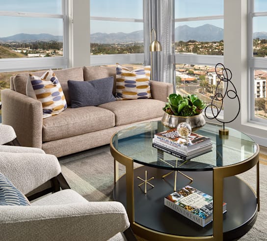 A living room with a couch, a coffee table, and a view of the mountains.