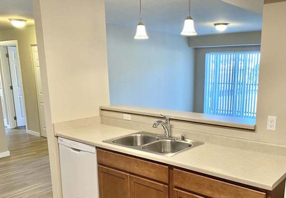 an empty kitchen with a sink and a refrigerator