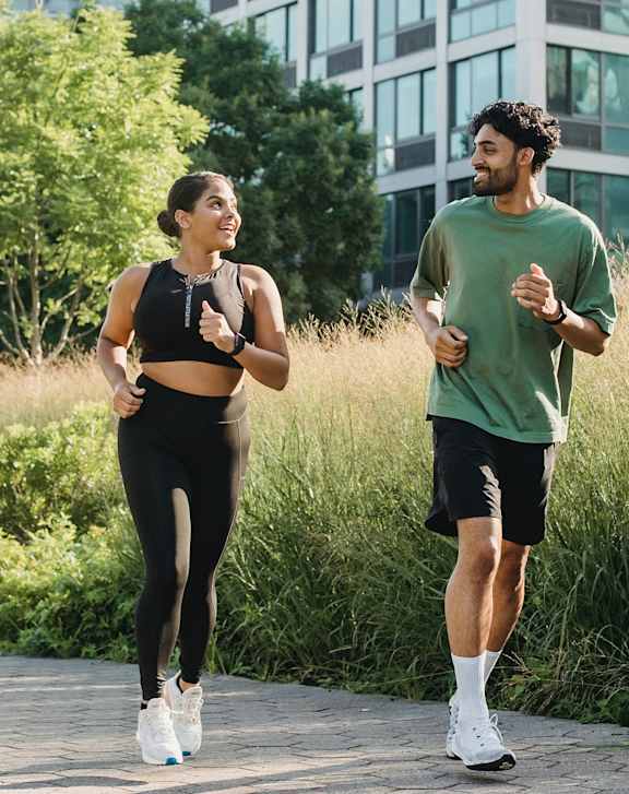 Two people jogging in a city park.