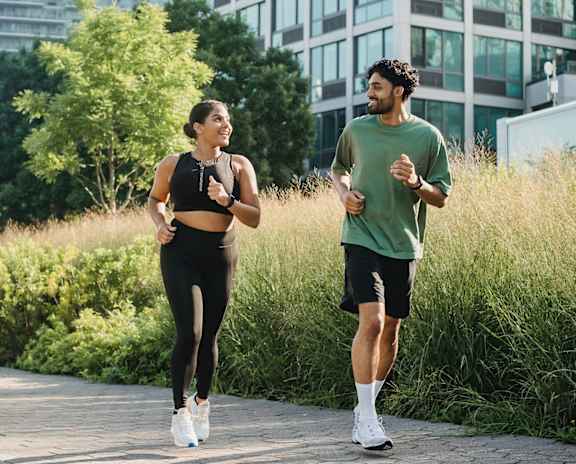Two people jogging in a city park.