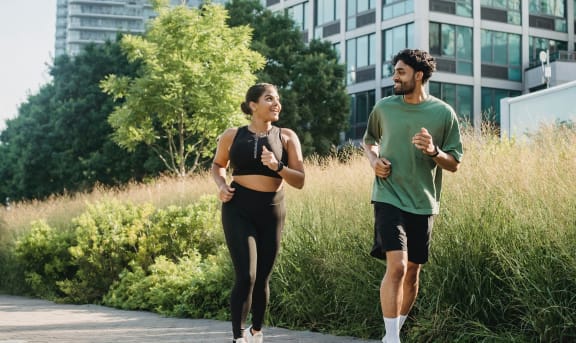 a man and a woman running down a sidewalk