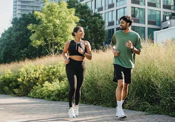 a man and a woman running down a sidewalk