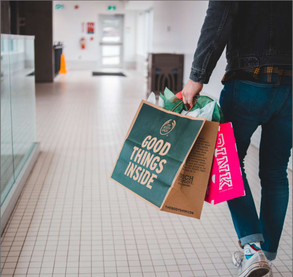 Man Walking Around Mall Carrying Shopping Bags