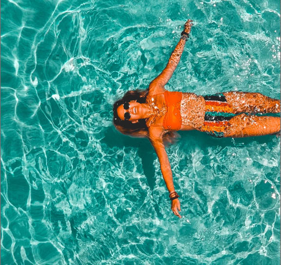 Woman Wearing Sunglasses and Smiling while Relaxing in Pool