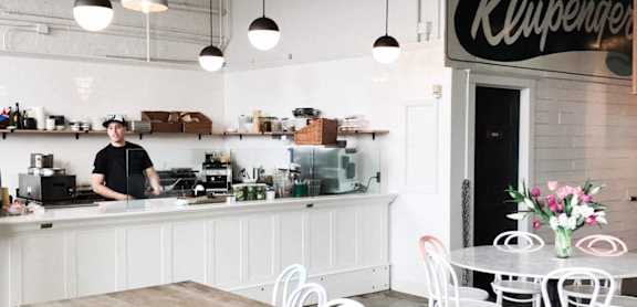 a man standing at a counter in a coffee shop