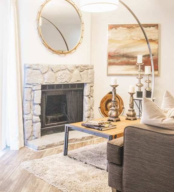 a living room with a fireplace and a mirror above it