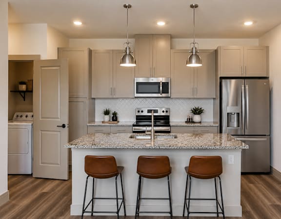 Modern kitchen with quartz countertops, stainless steel appliances, and bar seating.