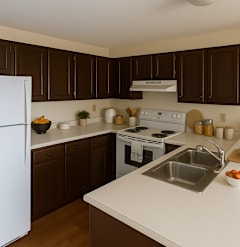 A white refrigerator is in a kitchen with brown cabinets.
