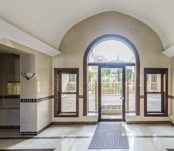 the entrance to the lobby of a building with an arched door and a window