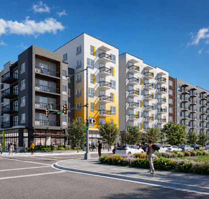 A modern apartment building with a mix of grey, yellow and white balconies.
