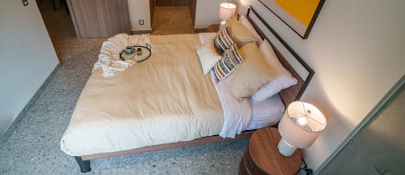 a bedroom with a bed with white sheets and pillows
