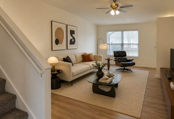 A living room with a staircase and a couch.