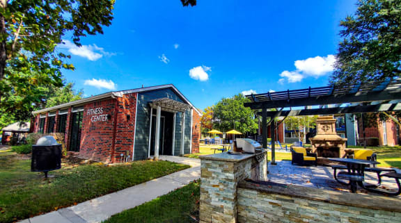 Outdoor grilling area with seating next to the fitness center apartments east austin