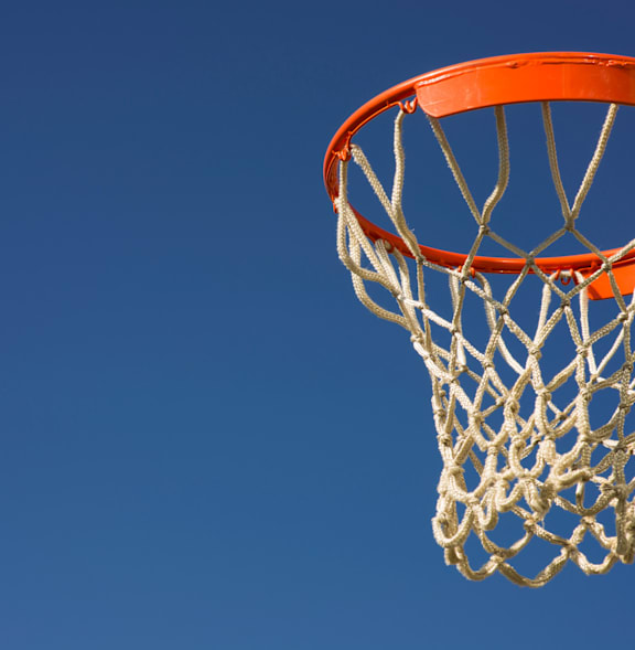 A basketball hoop with a blue sky in the background.