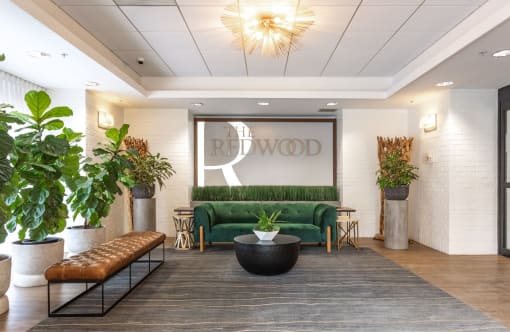 a lobby with a green couch and a large sign that reads the redwood  at The Redwood, Baltimore