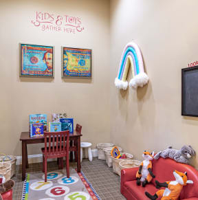 a childs play area with toys and a chalkboard on the wall