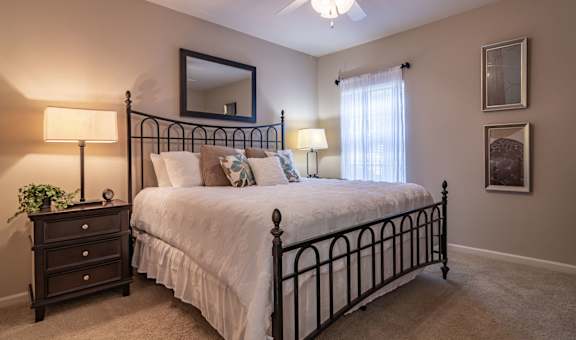 a bedroom with a bed and a ceiling fan