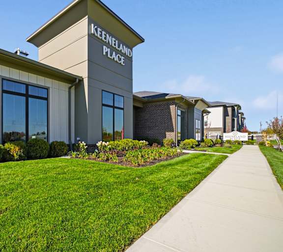 Keenland Place is a modern building with a green lawn in front.