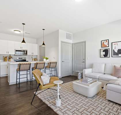 A modern living room with a white couch and a patterned rug.
