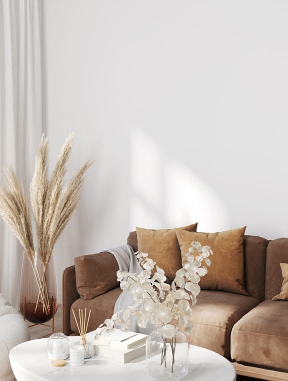 a living room with a couch and a coffee table with flowers on it at Allure at Edinburgh, Virginia