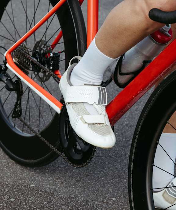A person is riding a bicycle wearing white shoes and socks.