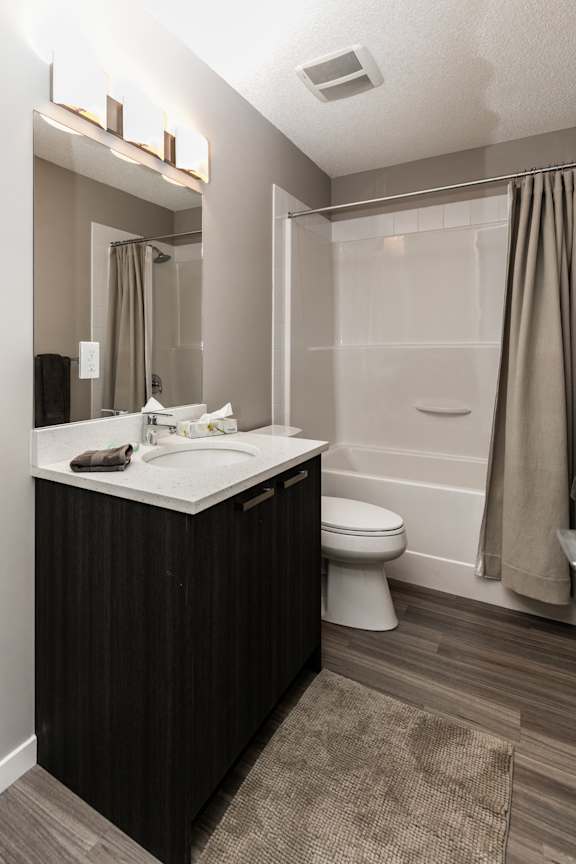 A bathroom with a white sink and a white toilet.